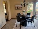 Cozy dining area with modern chandelier, black table and chairs with a sliding door to the deck at 2136 S Scranton Way, Aurora, CO 80014