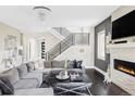 Spacious living room with hardwood floors, fireplace, modern staircase, and sophisticated decor at 3255 S Birch St, Denver, CO 80222