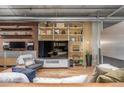 Comfortable living room featuring a large tv, bookshelves, and ample lighting at 1499 Blake St # 4F, Denver, CO 80202