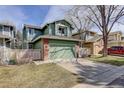 Inviting green exterior showcasing a two-story home with an attached two-car garage and brick accents at 8254 S Gaylord Cir, Centennial, CO 80122