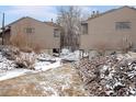 Backyard of home in the winter with a small creek, rocky embankment and exterior view of the building at 6700 W 11Th Ave # 103, Lakewood, CO 80214