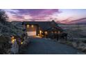 Stunning exterior of home with attached garage, beautiful rock wall, and a long driveway at 11730 Pointe View Dr, Longmont, CO 80503