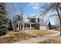 Charming two-story home featuring a welcoming front porch and well-manicured lawn at 6290 Virgil St, Arvada, CO 80403