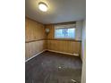 Small bedroom with wood paneling, neutral carpeting, and a window at 3246 S Nucla St, Aurora, CO 80013