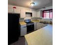 Kitchen features white cabinets, stainless steel appliances, and a breakfast bar at 3246 S Nucla St, Aurora, CO 80013