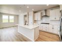 Modern kitchen featuring white cabinets, a center island, and stainless steel appliances at 39628 Yorktown Ter, Elizabeth, CO 80107