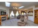 Bright living room featuring a fireplace, skylights and plush seating at 698 Larimer Creek Dr, Monument, CO 80132