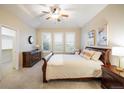 A bright bedroom with a walk-in closet, neutral walls, and light carpeting, with dresser, tables, and queen bed at 13943 W 87Th Ln, Arvada, CO 80005