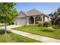 Well-manicured lawn and mature trees surround this home, offering beautiful curb appeal at 13943 W 87Th Ln, Arvada, CO 80005