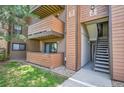 Apartment exterior with wood paneling, balconies, and staircase leading to unit entrances at 201 Wright St # 105, Lakewood, CO 80228