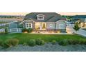 Charming home featuring well-maintained landscaping, lush green lawn, and a welcoming front porch at 10080 E 160Th Pl, Brighton, CO 80602