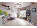 Open-concept living room with large windows, light wood floors, and quirky decor at 8707 E Florida Ave # 410, Denver, CO 80247