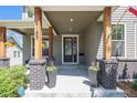Inviting front porch with rustic wood pillars and black brick accents at 4180 Ames St, Denver, CO 80212