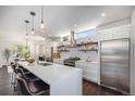 Modern kitchen featuring a large island, stainless steel appliances, and floating shelves at 4180 Ames St, Denver, CO 80212