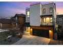 Modern three-story home with a rooftop deck and stone and white stucco facade with a two car garage at 9742 Fairwood St, Littleton, CO 80125