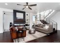 Open-concept living room with modern fireplace, floating shelves and a staircase with stainless steel banisters at 9742 Fairwood St, Littleton, CO 80125