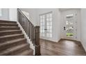 Bright foyer with hardwood floors, staircase, glass french doors, and a modern front door at 24708 E 40Th Ave, Aurora, CO 80019