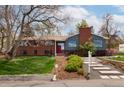 Beautiful front yard with lush lawn, manicured landscaping and a combination brick and siding exterior at 26 Morningside Dr, Wheat Ridge, CO 80215