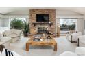 Open living room with stone fireplace, large windows, and stylish furniture at 26 Morningside Dr, Wheat Ridge, CO 80215
