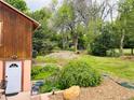 Lush backyard features mature trees, garden beds, and a well-maintained lawn at 8211 Rocky Mountain Dr, Lakewood, CO 80214
