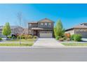 Lovely home featuring a stone facade, well-kept lawn, and an attached two-car garage at 25062 E Cedar Pl, Aurora, CO 80018