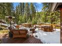 Outdoor deck featuring patio furniture, a heater, and snowy, scenic views at 27802 Shadow Mountain Dr, Conifer, CO 80433