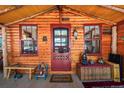 Cozy cabin entrance with a red door and charming decorations, creating a welcoming atmosphere at 27802 Shadow Mountain Dr, Conifer, CO 80433