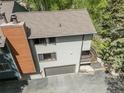 Aerial view of the multi-level home featuring an attached garage and a cozy second-floor balcony at 4843 Silver Spruce Ln, Evergreen, CO 80439