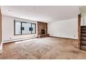 Spacious living room features a stone fireplace, carpeted floors, and large windows for ample natural light at 4843 Silver Spruce Ln, Evergreen, CO 80439