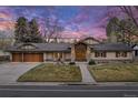 Charming stucco home with a tile roof, a two-car garage, manicured landscaping, and a stone porch at 26 Wedge Way, Littleton, CO 80123