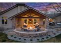 An outdoor patio with a seating area and fireplace, perfect for entertaining friends and Gathering at 26 Wedge Way, Littleton, CO 80123