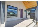 Inviting front porch with a modern aesthetic, featuring a purple front door and concrete landing at 1148 Hillside Ln, Louisville, CO 80027