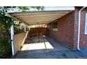 Attached carport with wooden privacy fence for covered parking and storage at 2211 Quebec St, Denver, CO 80207