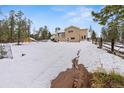 Expansive snowy backyard with a charming wooden fence and a view of a home featuring a cozy outdoor deck at 27987 Pine Grove Trl, Conifer, CO 80433