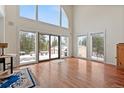 Bright living room with hardwood floors and a statement window boasting views of the trees and snow at 27987 Pine Grove Trl, Conifer, CO 80433