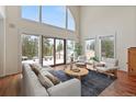 Bright living room with hardwood floors, a statement window, comfortable seating, and winter views at 27987 Pine Grove Trl, Conifer, CO 80433