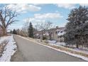 A view of the townhome exteriors along the walking path, showcasing the serene community setting at 1818 S Quebec Way # 11-3, Denver, CO 80231