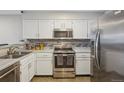 Well-lit kitchen featuring stainless steel appliances, white cabinets, and granite countertops at 1818 S Quebec Way # 11-3, Denver, CO 80231