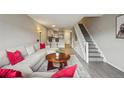 Inviting living room with a staircase, cozy seating, and views into the kitchen at 1818 S Quebec Way # 11-3, Denver, CO 80231