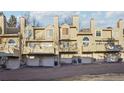 Exterior view of townhouses showing garages, balconies, and neutral color palette at 1818 S Quebec Way # 11-3, Denver, CO 80231