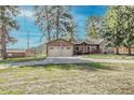 Charming home with detached two-car garage, American flag, front porch, and grassy yard at 23039 Isoleta Rd, Indian Hills, CO 80454