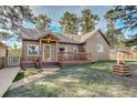 Inviting home with log siding, a decorative well, and a cozy front porch with flower boxes at 23039 Isoleta Rd, Indian Hills, CO 80454