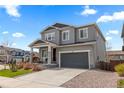 Two-story home showcasing gray siding, a two-car garage, and a charming covered front porch at 1114 Basalt Ridge Loop, Castle Rock, CO 80108
