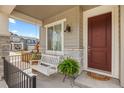 Cozy front porch featuring a hanging swing, stone accents, and a welcoming front door at 1114 Basalt Ridge Loop, Castle Rock, CO 80108