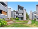 Daytime view of a stylish condo exterior with well-manicured lawn and inviting entrance at 9837 E Peakview Ave # D05, Englewood, CO 80111