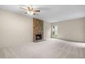 Open living room with a striking stone fireplace, neutral carpet, and bright natural light at 9837 E Peakview Ave # D05, Englewood, CO 80111