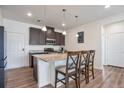 Stylish kitchen features a granite island with seating, dark cabinets, and stainless steel appliances at 16841 Askins Loop # 101, Parker, CO 80134