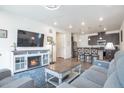 Open concept living room with fireplace, recessed lighting, and seamless flow into a modern kitchen at 16841 Askins Loop # 101, Parker, CO 80134