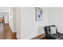 Bright hallway featuring wood floors, white walls and trim, and a decorative piece of artwork at 4125 Marble Dr, Longmont, CO 80504