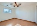 This bedroom has a neutral palette, wood laminate flooring, a ceiling fan, and a large window to let in the sunshine at 16259 W 10Th Ave # J5, Golden, CO 80401